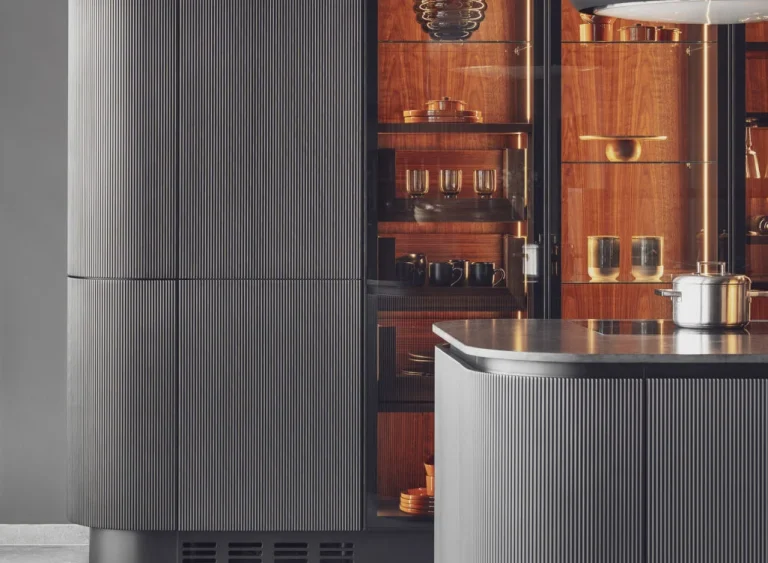 Stylish modern kitchen featuring black fluted fronts and warm oak-lit niches, creating a cozy yet sophisticated ambiance. Part of the Arta Kitchen Collection by MY-SPACE.