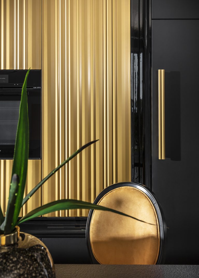 Modern kitchen with luxurious gold wavy fronts from the Ariana Kitchen Collection by MY-SPACE, perfect for a glamorous interior.